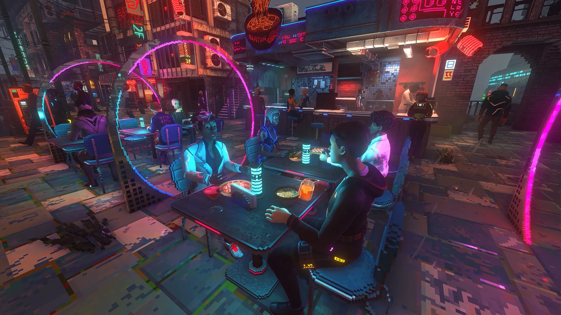 An outdoor dining area at night with customers at many tables under pink neon rings